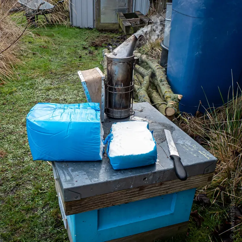 Beehive with a block of baker's sugar fondant, a knife and a smoker on top