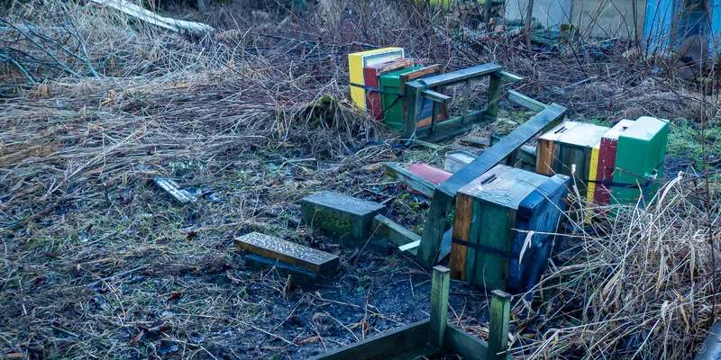 Bee hives scattered around on the ground after a storm