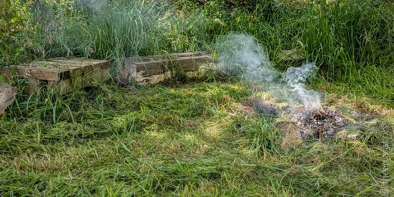 A smouldering fire in a grassy clearing