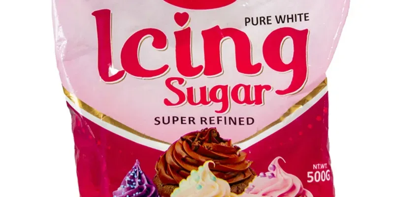 Photograph of a red and white plastic packet containing icing sugar