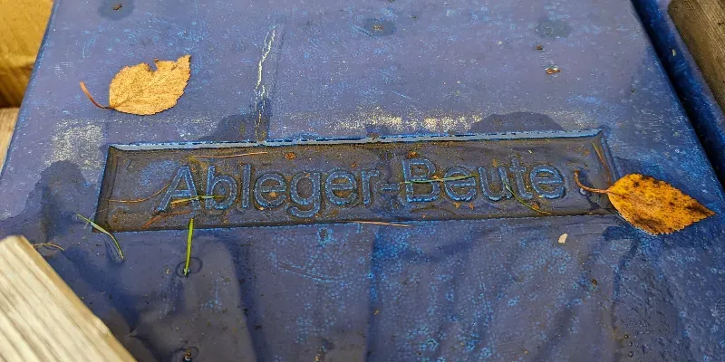 A blue bee hive roof with the name of the manufacturer embossed into the polystyrene