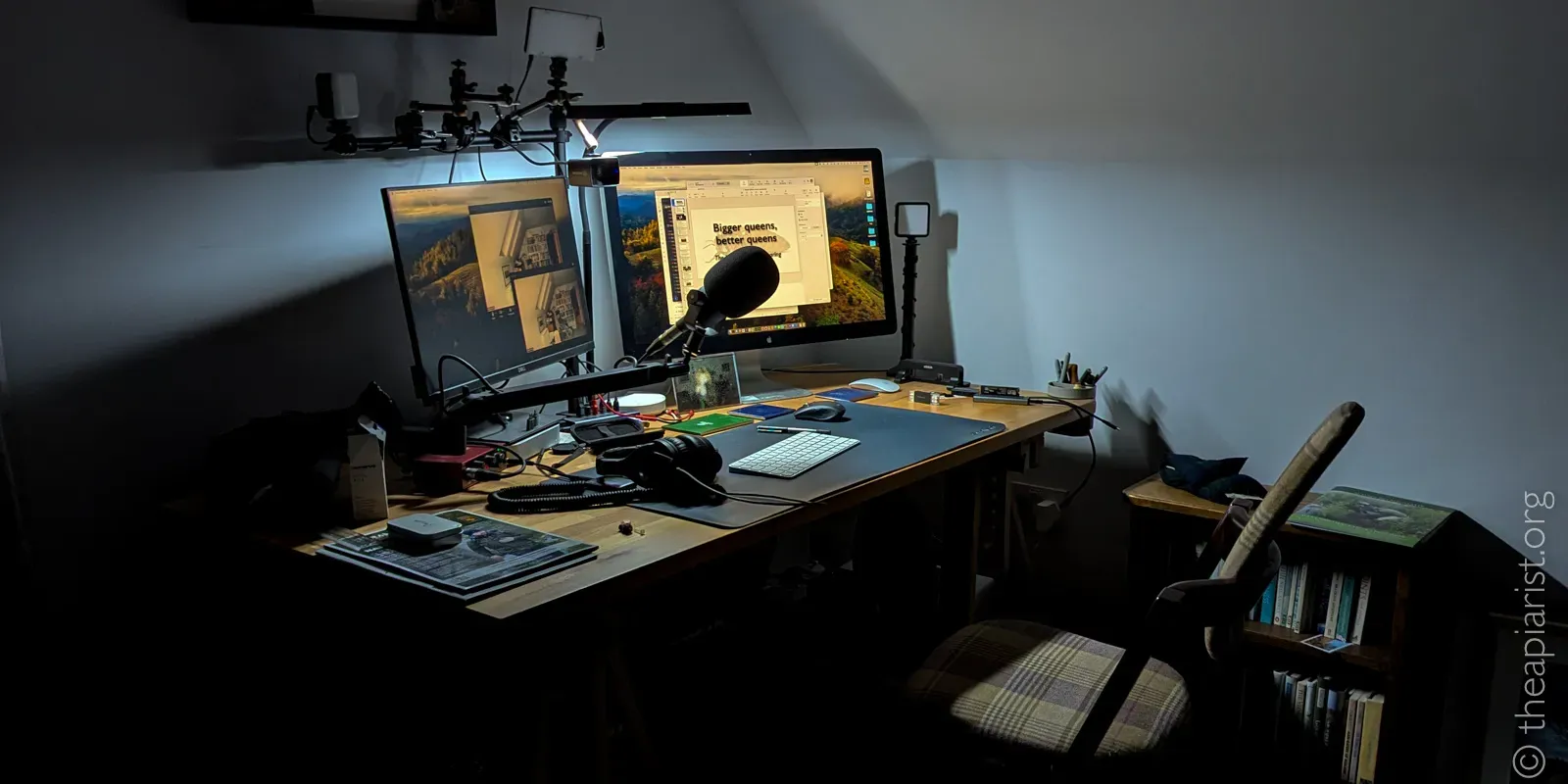 Picture of an office desk with two computer screens, a microphone and a chair