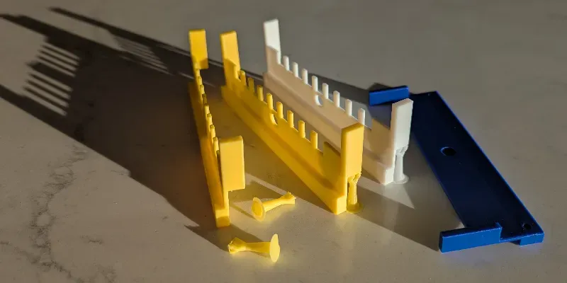 Yellow, blue and white 3D printed entrances for beehives that prevent mice from entering the hive.
