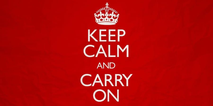 A poster with a red background and the words Keep Calm and Carry On centred underneath a Tudor crown.