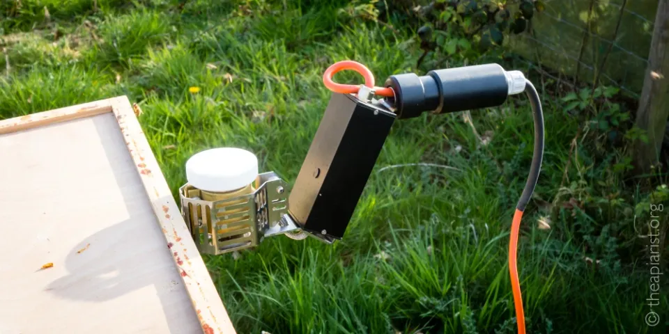 An electric-powered oxalic acid vaporiser inserted into the top of a bee hive